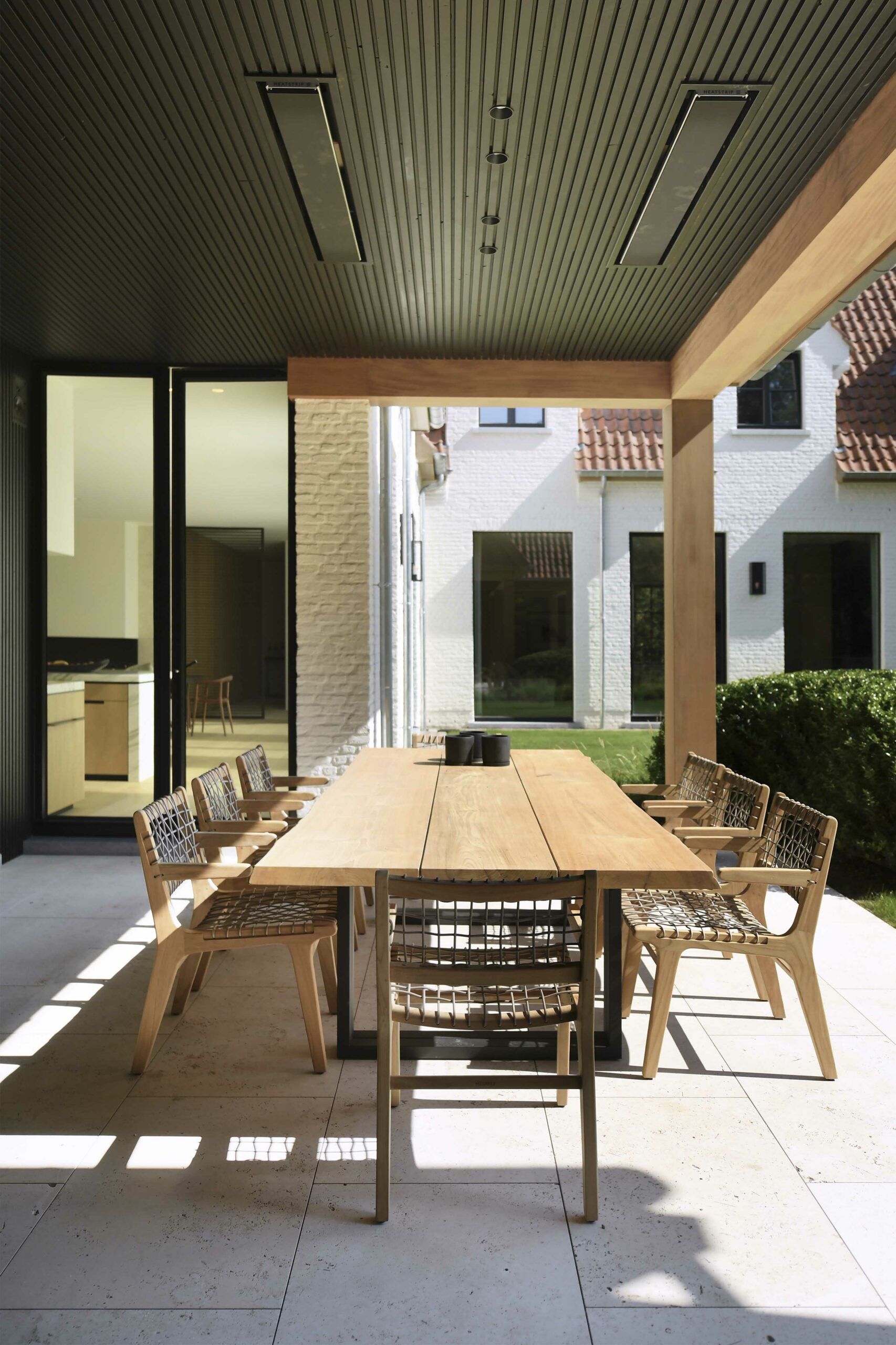 Outdoor dining area with wooden table and chairs.