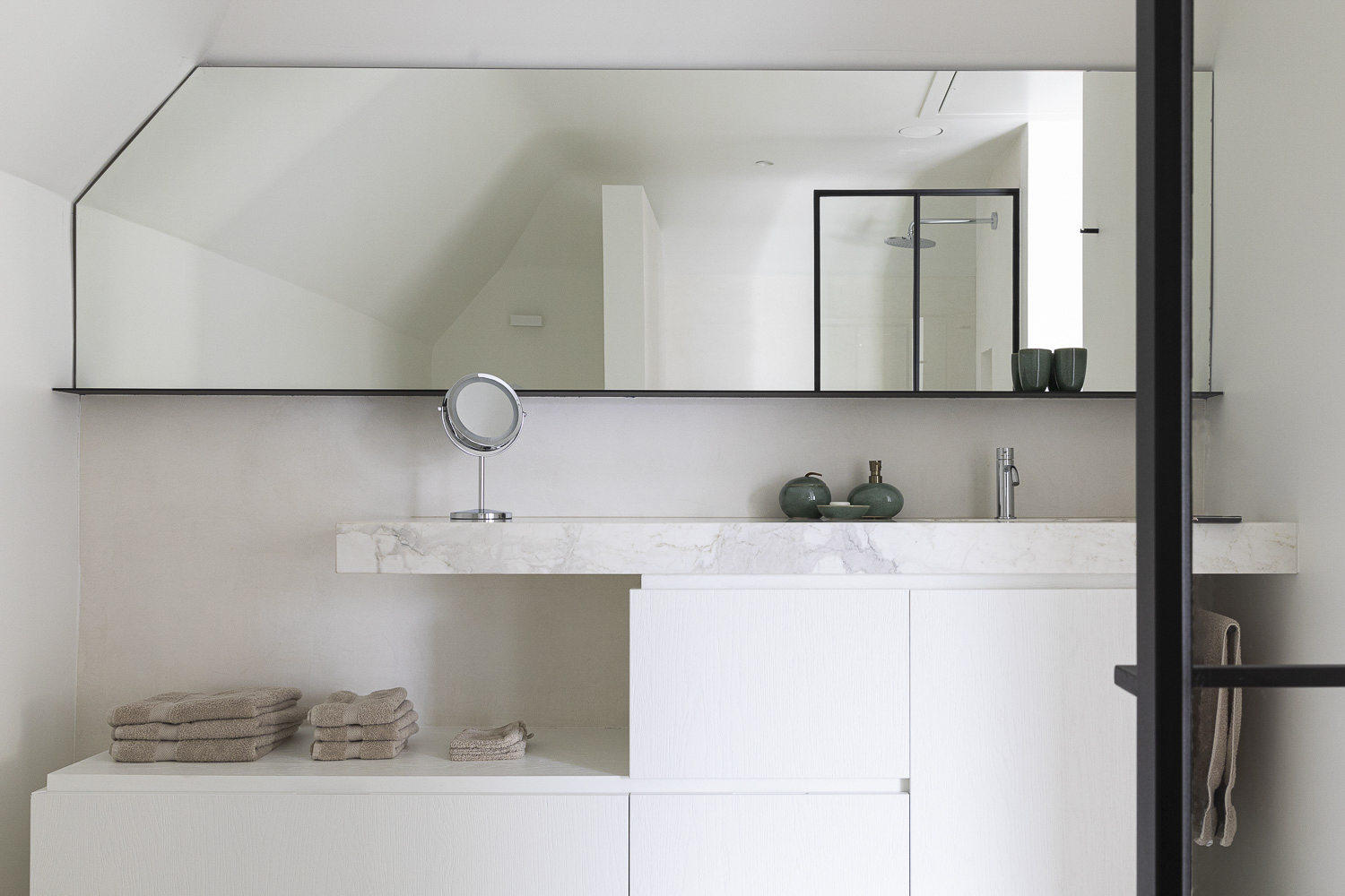 A bathroom with a white sink and mirror.