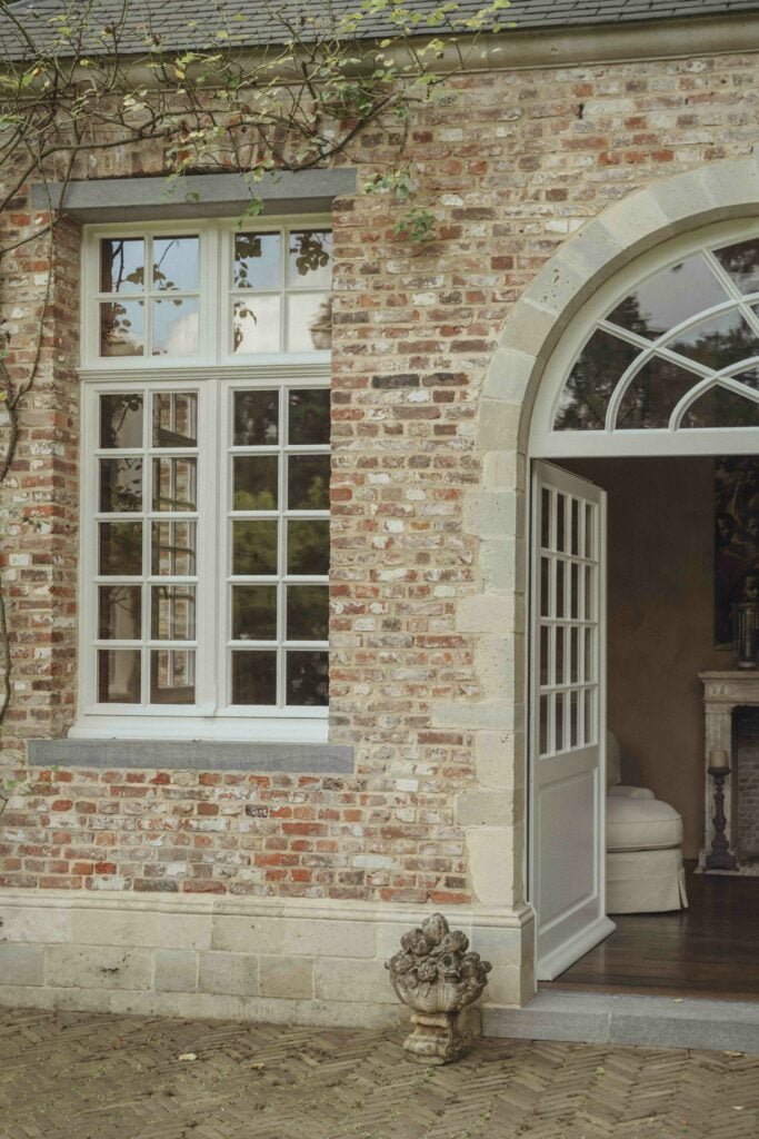 Klassieke villa met witte gevels, grote raampartijen en een eigentijds architecturaal ontwerp door Sels Villabouw.