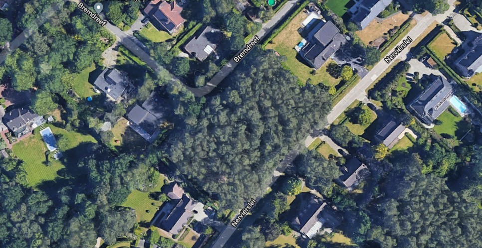 This is an aerial view of a residential area, showing houses and gardens. It depicts a green, spacious setting.