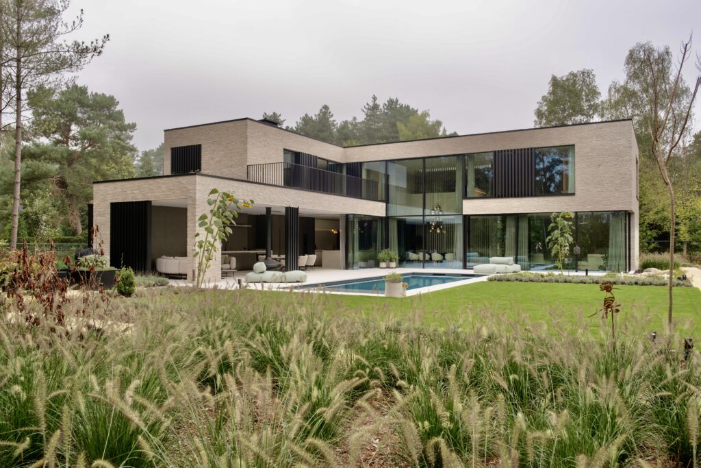 Strakke, moderne villa, grote raampartijen en een eigentijds architecturaal ontwerp door Sels Villabouw.