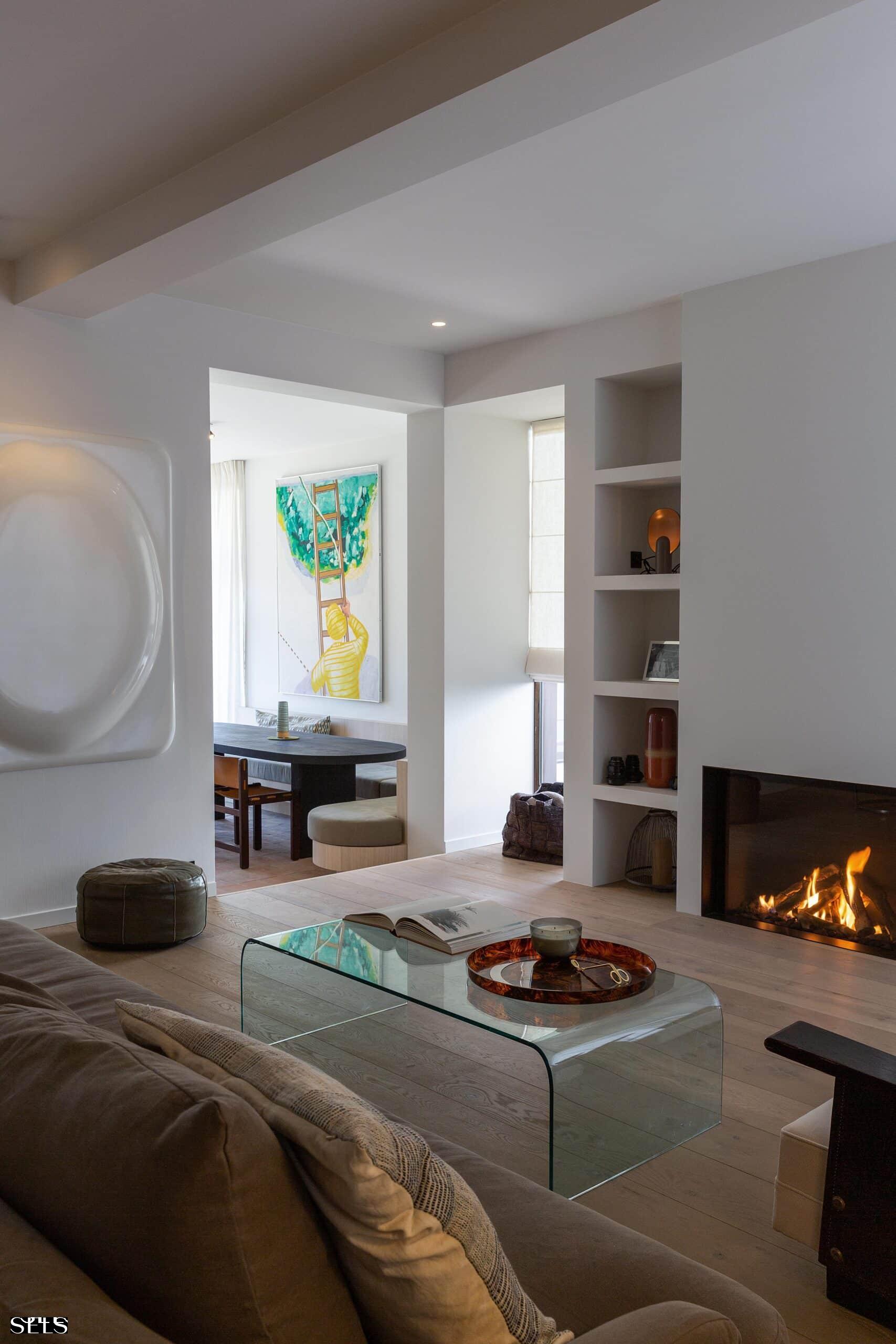 Lichte en open leefruimte met grote raampartijen en zicht op de tuin